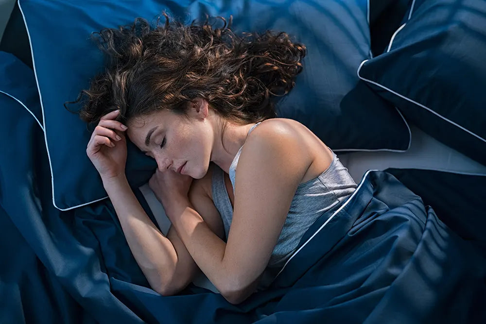 Schlafende Frau in blauem Bett